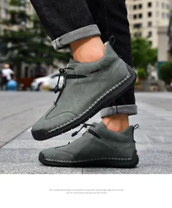 Close-up of grey hand-stitched outdoor casual leather boots with zipper on urban street
