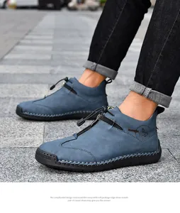 Detail of blue hand-stitched leather boots with zipper and toggle closure