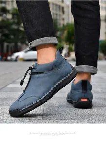 Side detail of blue hand-stitched casual leather boots featuring side zipper and drawstring