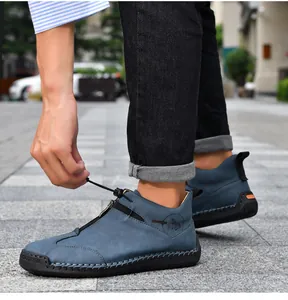 Macro view of blue leather boot featuring handmade stitching and side zipper detail