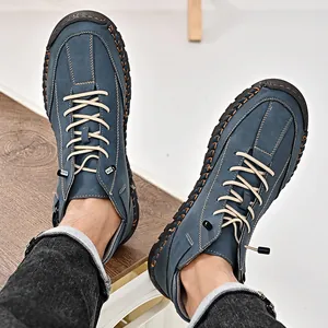 Close-up of blue men's casual leather boots with detailed orange hand-stitching.