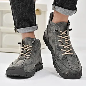 Detail of handmade stitching on grey distressed leather high-top men's boots