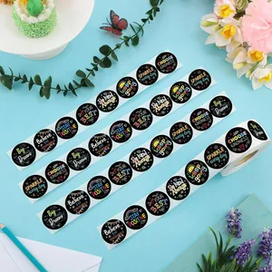 Close-up of black round stickers featuring colorful motivational English phrases