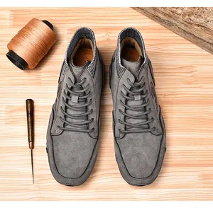Detalle de botas altas de ante gris para hombre con diseño de estilo británico retro