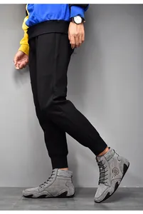 Detalle de botas altas de gamuza gris para hombre con cuello de punto suave