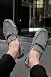 Makroansicht grauer Wildleder-Loafer mit handgenähten Details und schwarzer Schnalle