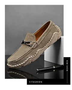 Nahaufnahme von hellbraunen Wildleder-Loafers mit handgenähten Details und Metallbit