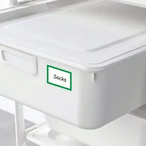 Dettaglio di un'etichetta adesiva bianca con bordo verde su un contenitore bianco