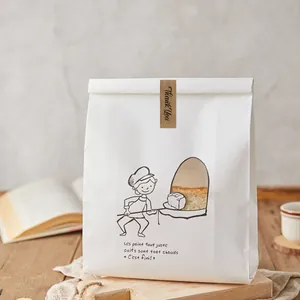Détail d'un autocollant en papier Kraft 'Thank You' sur un sac de boulangerie blanc