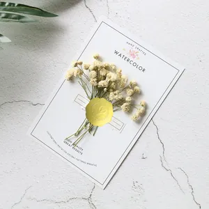 Close-up detail of golden embossed heart seal sticker used for wedding invitations