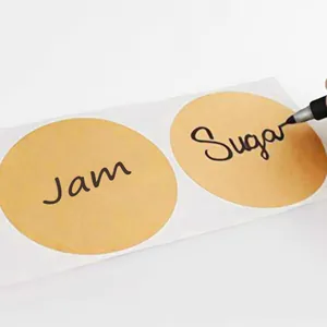 Detail van ronde kraftpapier etiketten met 'Sugar' en 'Jam' geschreven met een marker