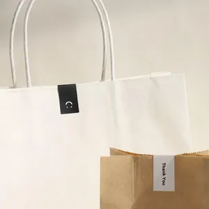 Detail showing Thank You and smiley face stickers applied to white and kraft paper bags