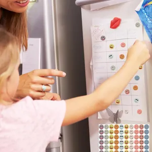 Child and parent using colorful smiley face stickers on a star reward chart macro