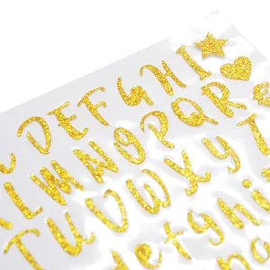 Primer plano de pegatinas de alfabeto con purpurina dorada y textura brillante detallada.
