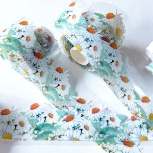Detail view of transparent PET tape featuring vibrant daisy and leaf patterns.