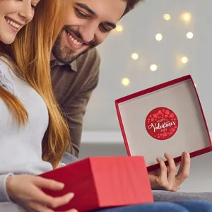 Close-up of a decorative Valentine's Day heart sticker inside a red gift box