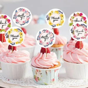 Primer plano de pegatinas de flores thank you usadas como adornos para cupcakes.