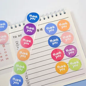 Primer plano de pegatinas redondas de colores de gracias en un cuaderno.