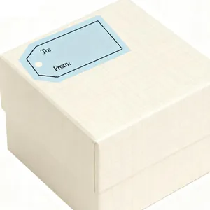 Close-up detail of a light blue gift tag sticker with To and From text on a cream box