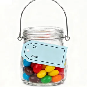Close-up of blue To: From: gift tags on a glass jar filled with candies