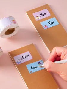 Detailed view of personalized cartoon name stickers applied to brown craft notebooks