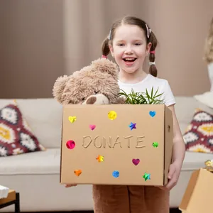 Child holding donation box decorated with colorful holographic reward stickers in heart and star shapes