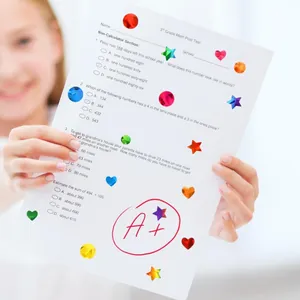Close-up of colorful holographic reward stickers in various shapes on a student test paper