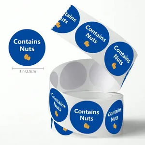 Detailed view of 1-inch round 'Contains Nuts' food warning stickers on a roll.