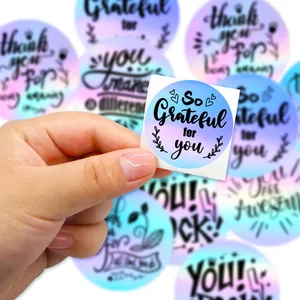 Primer plano de una pegatina holográfica circular con texto láser 'So Grateful for you'