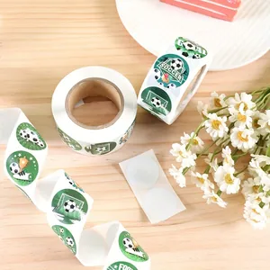 Close-up of green soccer-themed stickers on rolls with football and goal designs