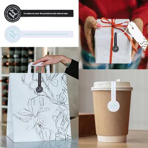 Close-up of handmade stickers on gift box, paper bag, and coffee cup packaging