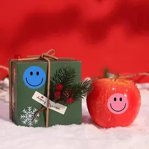 Close-up of 2.5cm colorful round smiley face reward stickers applied on a gift box