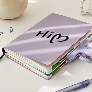 Détail d'un autocollant transparent 'Hi' avec cœur sur un carnet de notes violet