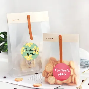Detailed view of round Thank You seal stickers on translucent matte gift packaging bags