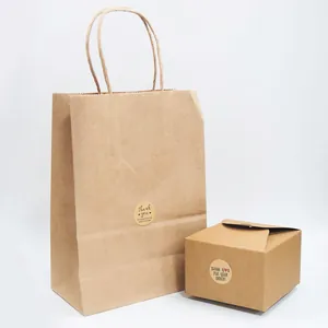 Primo piano di adesivi tondi in carta kraft di ringraziamento su confezioni regalo marroni