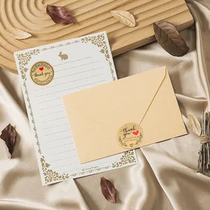 Primo piano di adesivi Thank You in carta kraft su carta da lettere artigianale.