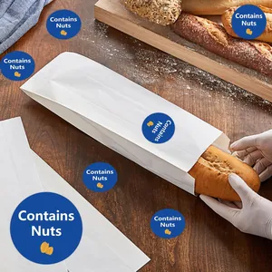 Close-up view of blue circular 'Contains Nuts' food safety sealing stickers on paper bags