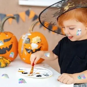 Child showing colorful holographic Halloween ghost stickers on skin and festive pumpkins