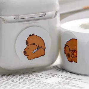 Detailaufnahme von niedlichen Cartoon-Capybara-Aufklebern auf einer Hülle und einer Rolle.