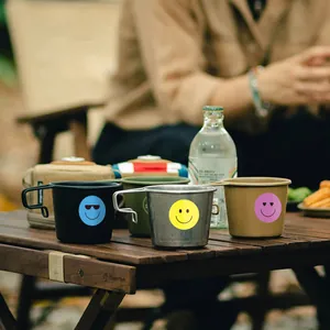 Close-up view of vibrant colorful smiley face emoji stickers used to decorate metal camping mugs