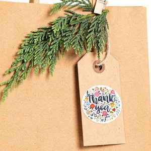 Détail d'autocollant floral Thank You sur étiquette en papier kraft et branche
