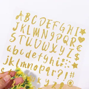 Primer plano de pegatinas de letras y números con purpurina dorada para manualidades DIY