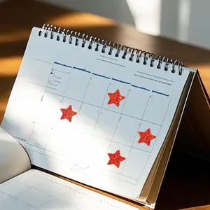 Close-up of red glittery star reward stickers applied on a white spiral desk calendar
