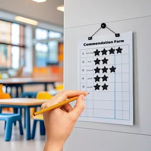 Detailed macro view showing black star reward stickers being applied to a school commendation form