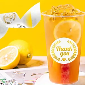 Detalle de pegatinas de agradecimiento con lámina de oro aplicadas en un vaso de bebida