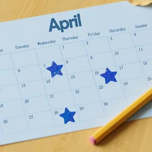 Blue holographic star stickers used for marking dates on a calendar with a pencil.