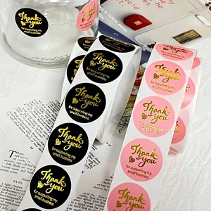 Close-up view of elegant pink and black gold foil Thank You stickers for gift packaging