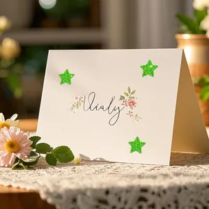 Close-up of green glitter star stickers on a white card for creative decoration and rewards.