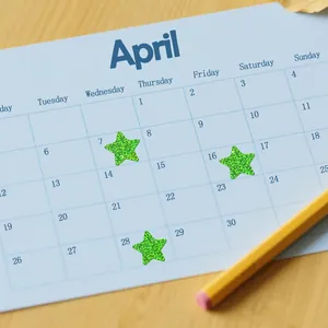 Close-up of green glitter star stickers applied to a calendar for kids rewards and planning