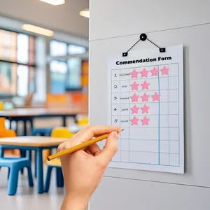 Close-up of pink star reward stickers applied on a commendation form in a classroom setting